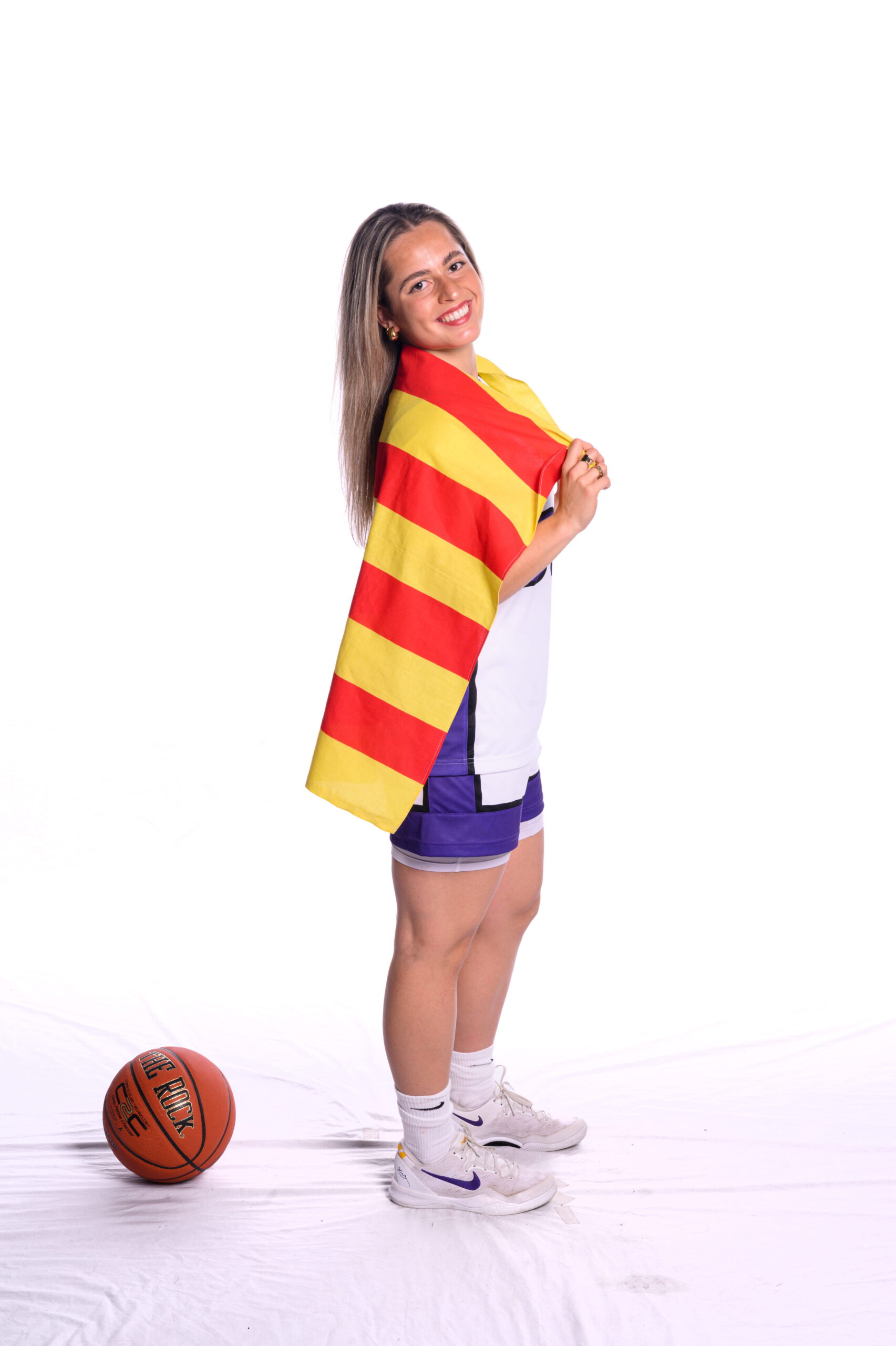 Laia Albàs Ferrer standing next to a basketball holding a Barcelona flag.