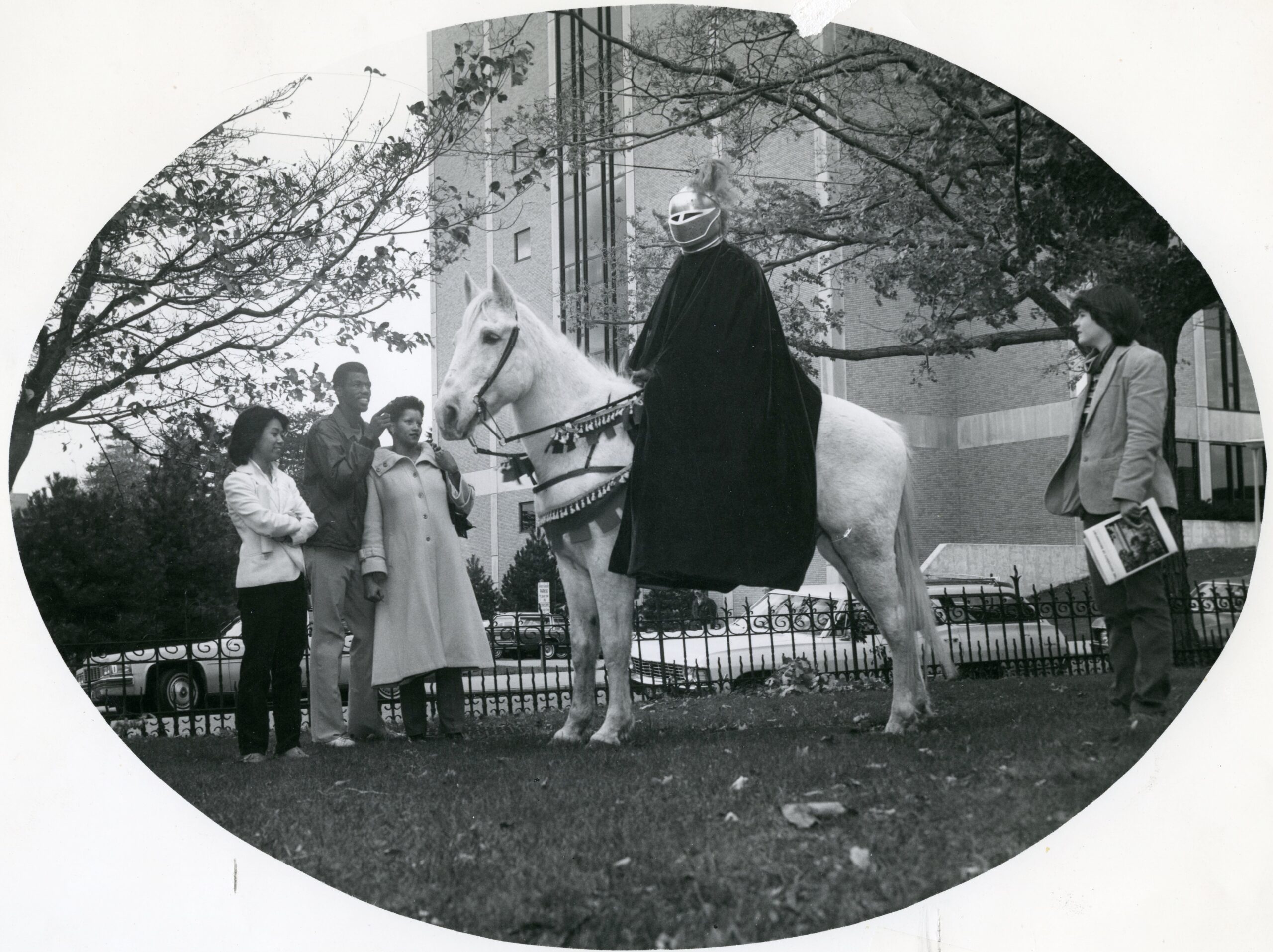 University of Bridgeport students gather around the Purple Knight mascot, who is seated on horseback.