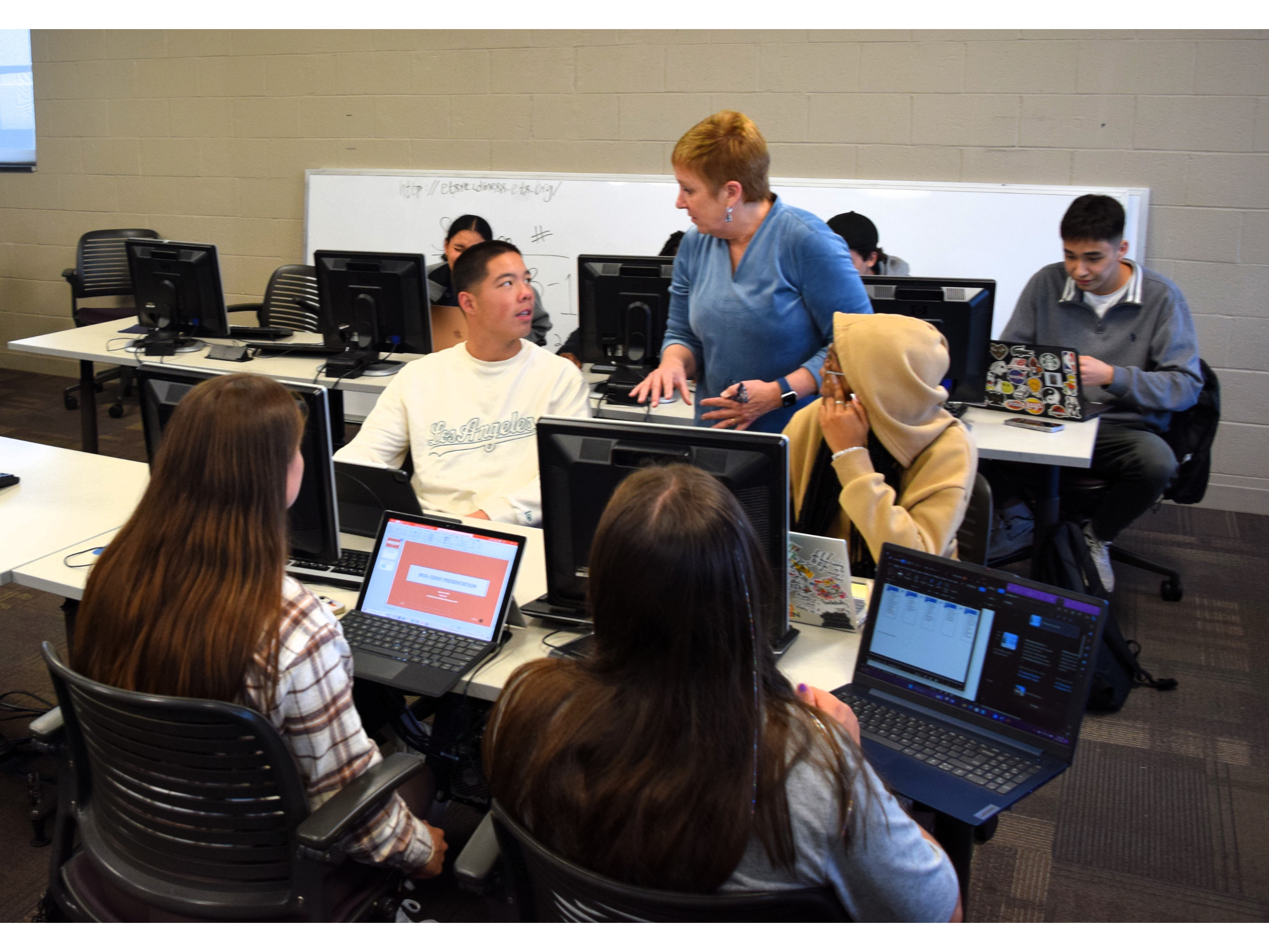 Professor leading an interactive session with college students in a computer lab